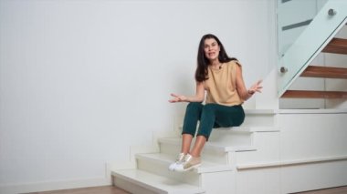 Merdivenlerde oturan bir kadın.