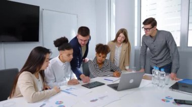 Takım lideri toplantıda ekip üyeleriyle büyüme grafiğini tartışıyor