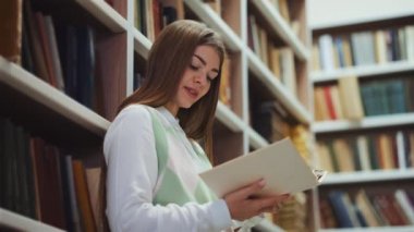 Kütüphanede romantik kitap okuyan bir kadın