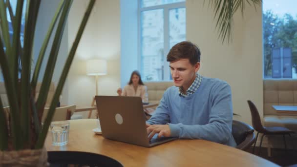 Man werkt op afstand vanuit café met laptop — Stockvideo