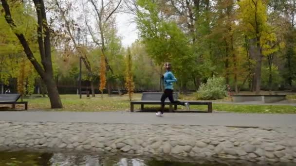 Corredor de cámara lenta corriendo por el río en el parque — Vídeos de Stock