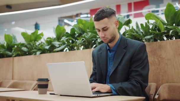 Empresário trabalhando remotamente no laptop no café — Vídeo de Stock