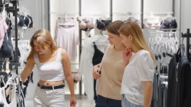 Kadınlar iç çamaşırı dükkanında birlikte alışveriş yapıyor.