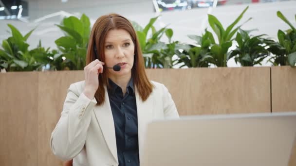 Obchodní žena dává online konzultace pomocí sluchátek a notebooku — Stock video