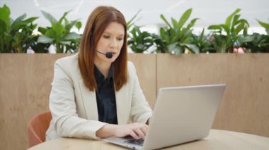 İş yerinde kulaklık ve dizüstü bilgisayar kullanan acil durum operatörü