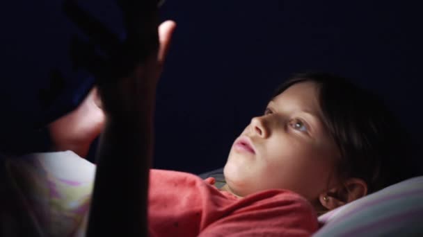 Kislány fekszik az ágyban, és használja tabletta éjjel — Stock videók