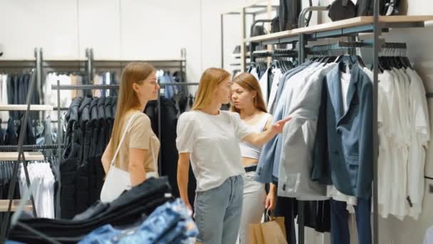 Las mujeres de compras en la tienda de ropa masculina elegir la ropa para el novio — Vídeos de Stock