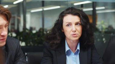 İş kadını iş arkadaşlarıyla toplantıda konuşuyor