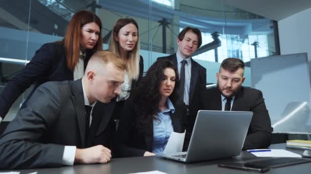 Business team a seguito di notizie su laptop deluso con i risultati — Video Stock