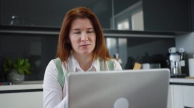 Evde bilgisayarla arkadaşlarıyla sohbet eden bir kadın.