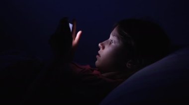 Küçük kız gece akıllı telefon kullanıyor.