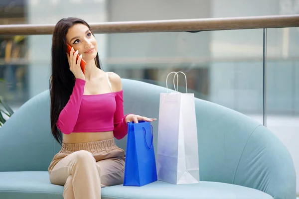 Radosna kobieta rozmawiająca przez telefon w centrum handlowym — Zdjęcie stockowe
