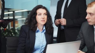 Kadın CEO toplantıda iş ekibiyle konuşuyor.