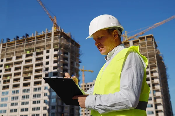 Inspector at construction site making notes on paper Royalty Free Stock Photos