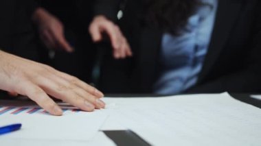 Belgelerle çalışan ve grafikleri kontrol eden iş adamlarının elleri