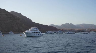Gün batımında deniz koyuna park edilmiş bir yat.