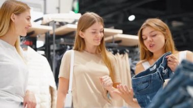Alışveriş merkezinde kot pantolon seçen kadınlar