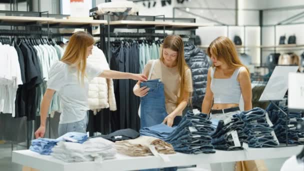 Comprando juntos tres mujeres eligiendo jeans — Vídeos de Stock