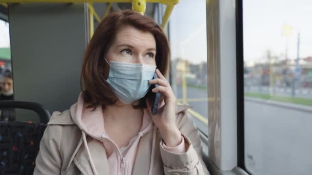 Mujer con máscara hablando por teléfono mientras viaja en autobús — Vídeos de Stock