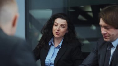 Çekici bir iş kadını toplantıda iş arkadaşlarıyla konuşuyor.