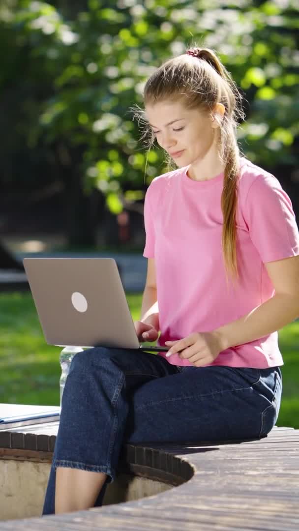 Pantalla vertical: Mujer trabajando en el ordenador portátil en el parque — Vídeos de Stock
