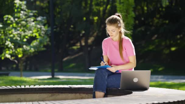 Studentka studující venku pomocí notebooku — Stock video