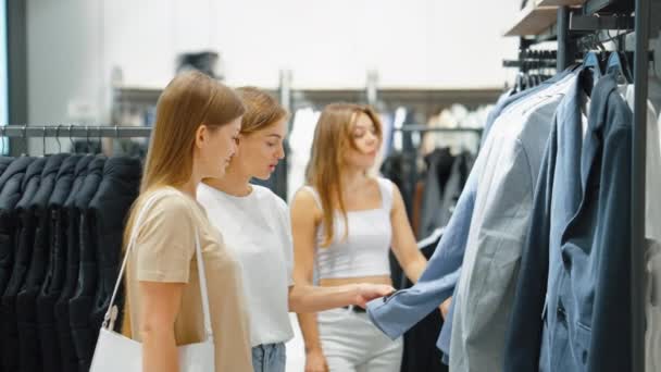 A nők együtt vásárolnak a férfi ruhaboltban. — Stock videók