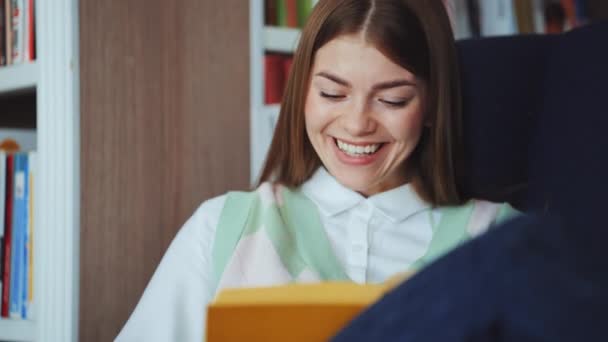Mujer leyendo divertido libro y riendo — Vídeos de Stock