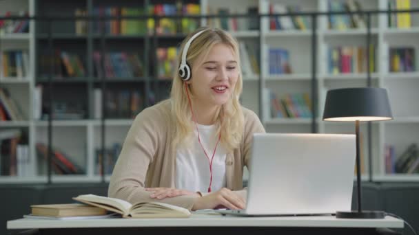 Teenage Girl Wearing Headphones Having Video Call Laptop Welcome Someone — Stock video