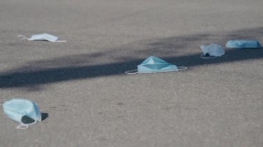 Asfalt yolda duran tıbbi maskeler. Salgın sonrası terk edilmiş ölü şehir görüntüsü. Kıyametin kavramı