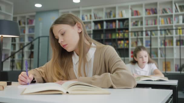 Шкільна Дівчина Довгим Волоссям Повсякденному Одязі Сидить Столом Пише Книзі — стокове відео