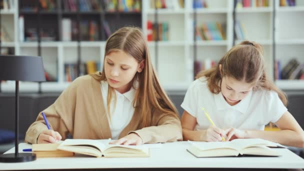 Children Wearing Uniform Sitting Desk Writing Exercise Books Talking Looking — ストック動画