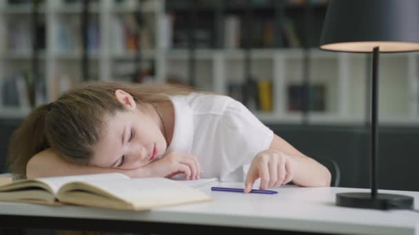 Втомлена Шкільна Дівчина Лежить Столі Грає Ручкою Щоб Розважити Себе — стокове відео