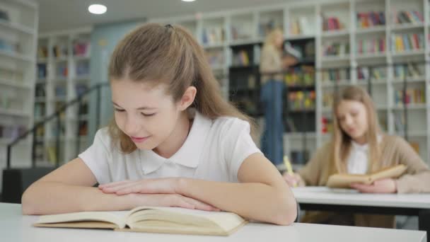 Шкільна Дівчина Сидить Столом Сміється Читаючи Кумедну Книгу Інший Учень — стокове відео