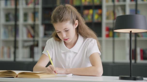 Розумна Школярка Сидить Столом Пише Тренувальній Книзі Лампа Поруч Нею — стокове відео