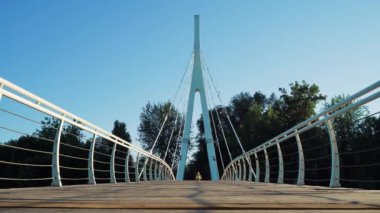 Active woman jogging on city footbridge. Female athlete prepares for marathon. Attractive fit girl running morning training. Healthy, fitness, wellness lifestyle. Sport and cardio workout concept
