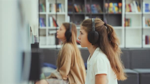 Les Filles Assises Classe Portant Des Écouteurs Regardant Appareil Sur — Video