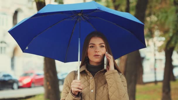 Attraktive Junge Frau Mit Blauem Regenschirm Telefoniert Der Verregneten Herbststadt — Stockvideo