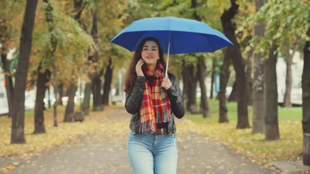 Beautiful Young Woman Wearing Checkered Scarf Blue Umbrella Talking Phone — Stock Video