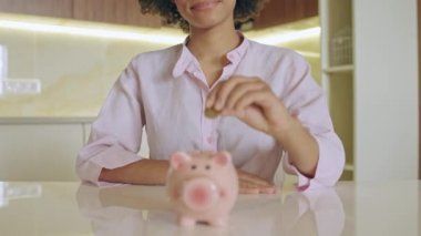 Genç mutlu kadın kumbaraya para koyuyor, satın almak için para biriktiriyor.