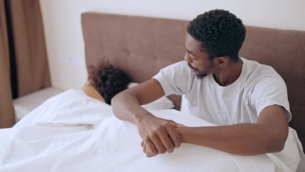 不幸な若い男が眠っている妻の近くのベッドに座って うつ病 — ストック動画