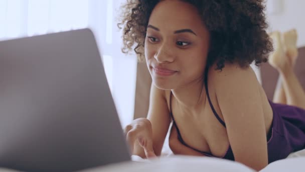 Χαλαρωμένη Μαύρη Γυναίκα Ξαπλωμένη Στο Κρεβάτι Περιήγηση Ιστοσελίδες Στο Laptop — Αρχείο Βίντεο