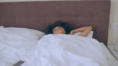 Siyahi kadın uyuyakalmış, sabah çok geç kalkmış, işe gitmek için acele ediyor.
