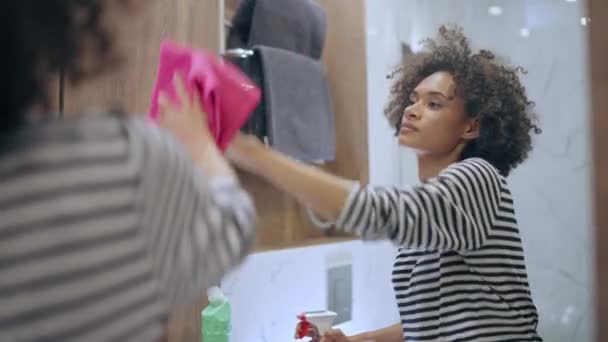 快乐的年轻女性在浴室的镜子上喷洒清洁剂 舒适舒适的家居 — 图库视频影像
