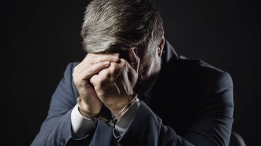 Elleri kelepçeli bir erkek memur rüşvet, yolsuzluk ve adalet alırken yakalandı.