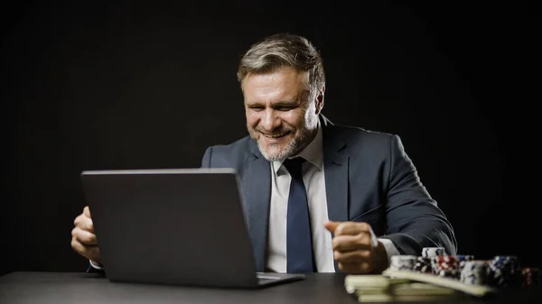 İş adamı başarılı online bahsi kutluyor, pokerde kazanıyor, kumar oynuyor.
