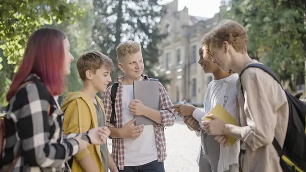 Çok ırklı ortaokul öğrencileri dersten sonra konuşuyor, birlikte takılıyorlar.