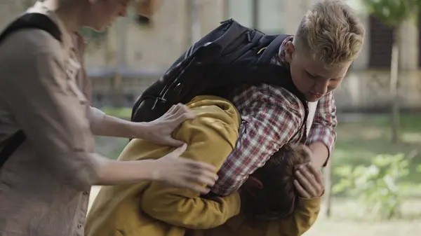 İki güçlü çocuk, zayıf liseli çocuğu dövüyor. Fiziksel taciz sorunu var.