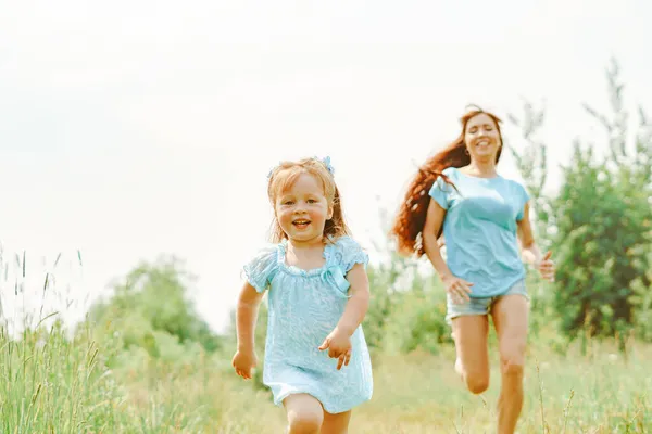 Uma Menina Vestido Azul Corre Para Sua Mãe Grama Descalça Fotos De Bancos De Imagens Sem Royalties