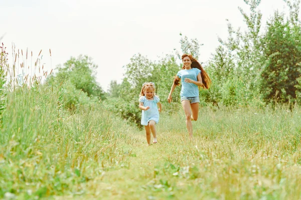 Dochter loopt naar haar moeder op het gras — Stockfoto